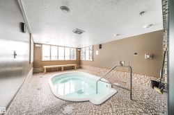 View of pool featuring a hot tub and a sunroom - 
