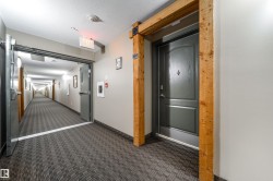 Hallway with a barn door, dark carpet, and a textured ceiling - 