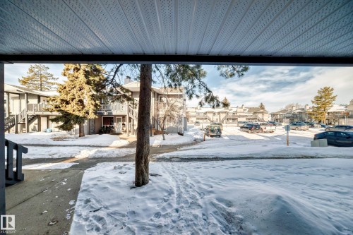 Snowy yard featuring a residential view and stairway - 23 1503 Mill Woods Road E, Edmonton, AB - Outdoor