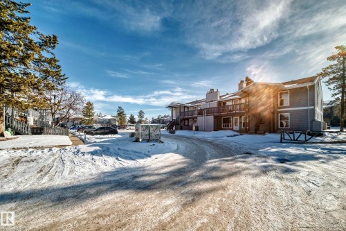Snowy yard featuring a wooden deck and a residential view - 23 1503 Mill Woods Road E, Edmonton, AB - Outdoor