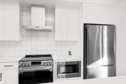 Kitchen with white cabinets, open shelves, SMART LG appliances, exhaust hood, quartz counters, tile backsplash, and modern cabinets. Enjoy! - 