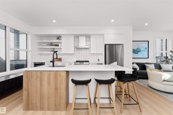 Kitchen with white cabinets, open shelves, SMART LG appliances, exhaust hood, quartz counters, tile backsplash, and modern cabinets. Enjoy! - 