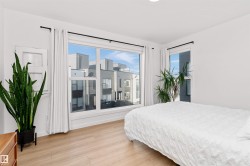 Bedroom with light wood-type flooring and corner wrapped windows. - 