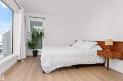 Bedroom with light wood-type flooring and corner wrapped windows. - 