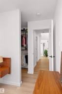 Hallway with light wood-style floors featuring the entrance to the walk-in closet. - 