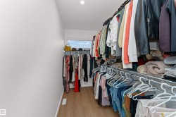 Walk in closet with light wood-style flooring and extra window. - 