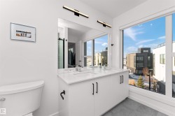 Bathroom featuring double vanity and dark tile patterned floors, with beautiful tiled custom shower. - 
