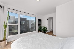 Bedroom featuring light wood-style flooring, walking closet, and large bright corner wrapped windows. - 
