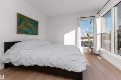 Bedroom featuring light wood-style flooring, walking closet, and large bright corner wrapped windows. - 