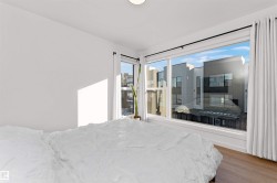 Bedroom featuring light wood-style flooring, walking closet, and large bright corner wrapped windows. - 