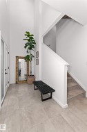 Foyer with a high ceiling and stairway on the ground level. Next to den/office and double garage entrance. - 