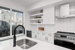 Kitchen with white cabinets, open shelves, SMART LG appliances, exhaust hood, quartz counters, tile backsplash, and modern cabinets. Enjoy! - 