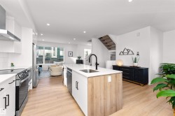 Kitchen with white cabinets, open shelves, SMART LG appliances, exhaust hood, quartz counters, tile backsplash, and modern cabinets. Enjoy! - 