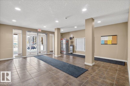 Building lobby with a textured ceiling and recessed lighting - 305 12045 22 Avenue, Edmonton, AB - Indoor Photo Showing Other Room