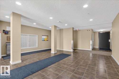 Community lobby with a textured ceiling and recessed lighting - 305 12045 22 Avenue, Edmonton, AB - Indoor Photo Showing Other Room