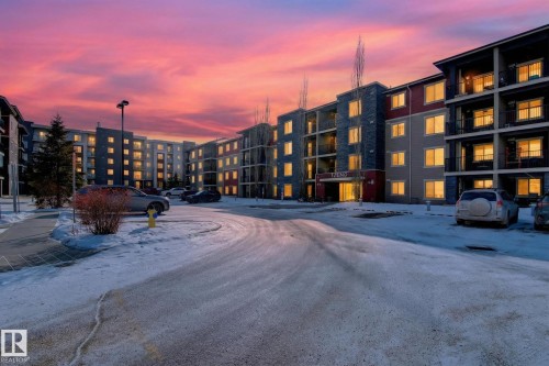 Snow covered building featuring a view of apartment building / complex and uncovered parking - 305 12045 22 Avenue, Edmonton, AB - Outdoor With Facade