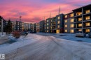Snow covered building featuring a view of apartment building / complex and uncovered parking - 305 12045 22 Avenue, Edmonton, AB  - Outdoor With Facade 