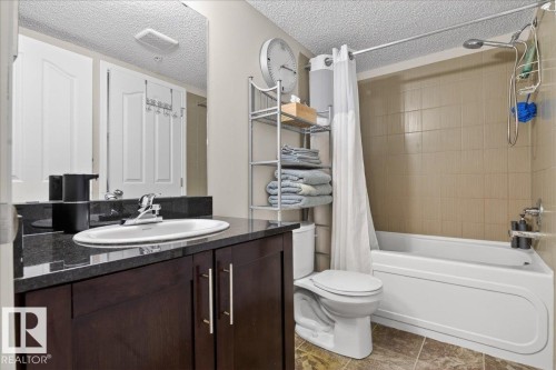 Full bath featuring vanity, shower / tub combo, and a textured ceiling - 305 12045 22 Avenue, Edmonton, AB - Indoor Photo Showing Bathroom
