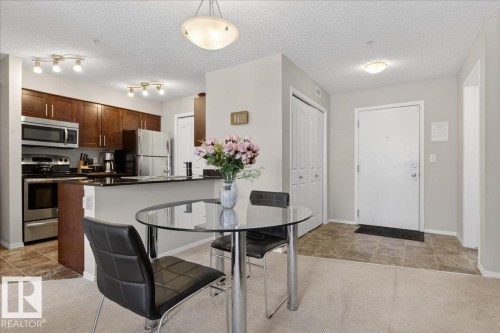 Dining room with light carpet, a textured ceiling, and light tile patterned floors - 305 12045 22 Avenue, Edmonton, AB - Indoor