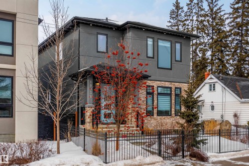 Modern home with a fenced front yard, stone siding, and stucco siding - 10038 142 Street, Edmonton, AB - Outdoor