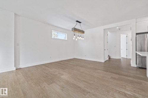 Unfurnished dining area with light wood-type flooring and baseboards - 10038 142 Street, Edmonton, AB - Indoor Photo Showing Other Room