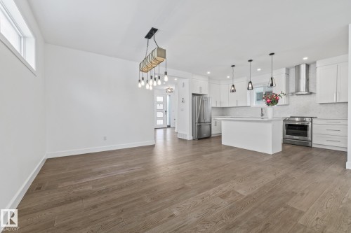 Kitchen featuring light countertops, high end appliances, white cabinetry, open floor plan, and a kitchen island - 10038 142 Street, Edmonton, AB - Indoor Photo Showing Kitchen