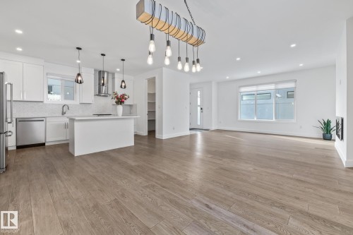 Kitchen with light countertops, open floor plan, white cabinets, and backsplash - 10038 142 Street, Edmonton, AB - Indoor Photo Showing Kitchen With Upgraded Kitchen