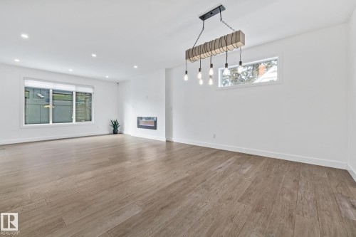 Unfurnished living room with light wood finished floors and recessed lighting - 10038 142 Street, Edmonton, AB - Indoor
