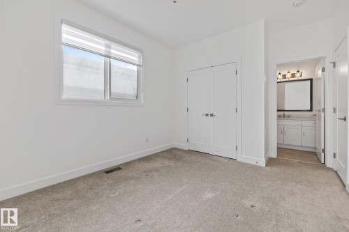 Unfurnished bedroom with light colored carpet, a closet, and connected bathroom - 10038 142 Street, Edmonton, AB - Indoor Photo Showing Other Room