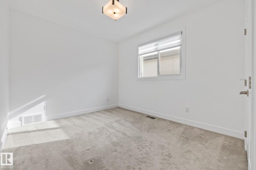 Empty room with baseboards and light colored carpet - 10038 142 Street, Edmonton, AB - Indoor Photo Showing Other Room
