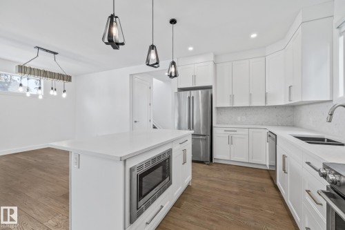 Kitchen featuring stainless steel appliances, white cabinets, backsplash, and dark wood-type flooring - 10038 142 Street, Edmonton, AB - Indoor Photo Showing Kitchen With Double Sink With Upgraded Kitchen