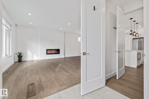 Unfurnished living room with recessed lighting, light wood-style floors, and a glass covered fireplace - 10038 142 Street, Edmonton, AB - Indoor Photo Showing Other Room