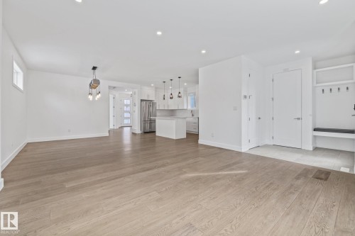 Unfurnished living room with light wood-style flooring, recessed lighting, and healthy amount of natural light - 10038 142 Street, Edmonton, AB - Indoor