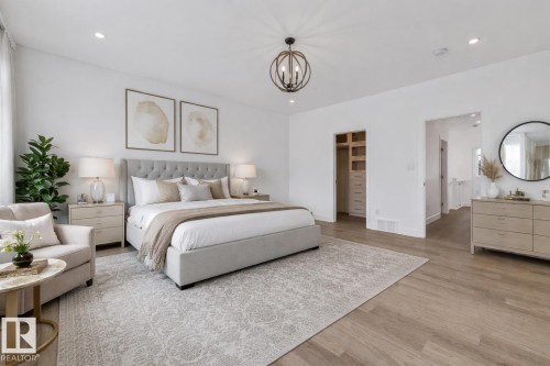 Bedroom with a walk in closet, light wood-style floors, and hanging lights - 10038 142 Street, Edmonton, AB - Indoor Photo Showing Bedroom