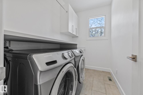 Laundry room featuring cabinet space and washing machine and clothes dryer - 10038 142 Street, Edmonton, AB - Indoor Photo Showing Laundry Room
