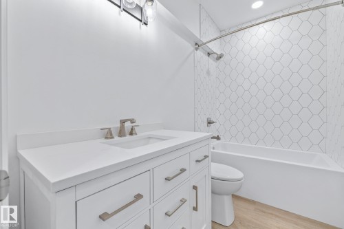 Bathroom featuring vanity, light wood-style floors, and shower / bathtub combination - 10038 142 Street, Edmonton, AB - Indoor Photo Showing Bathroom