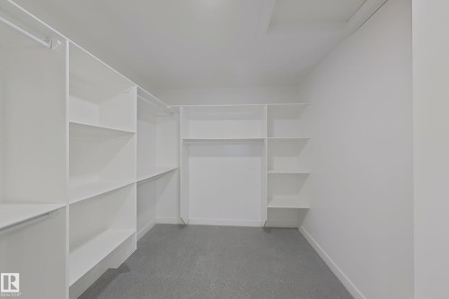 Walk in closet with dark colored carpet - 3158 Magpie Way, Edmonton, AB - Indoor With Storage