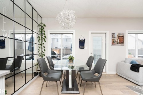 Dining room with light wood-style flooring and hanging lights - 43 1703 16 Avenue, Edmonton, AB - Indoor Photo Showing Dining Room