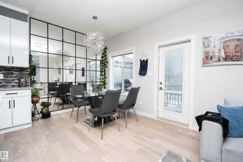 Dining space with light wood finished floors and hanging lights - 43 1703 16 Avenue, Edmonton, AB - Indoor