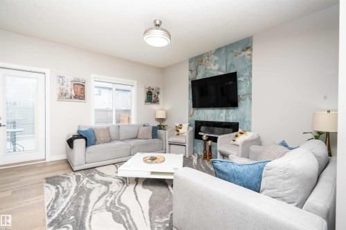 Living area with wood finished floors and a fireplace - 43 1703 16 Avenue, Edmonton, AB - Indoor Photo Showing Living Room