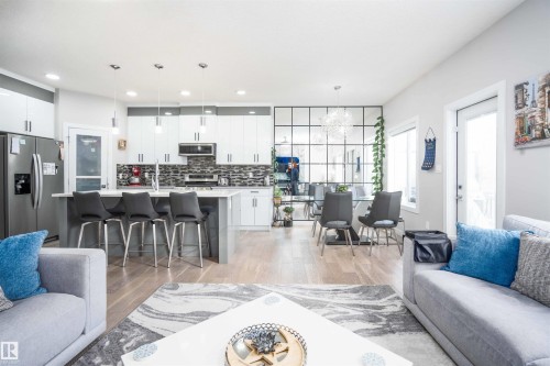 Living area with light wood finished floors and a chandelier - 43 1703 16 Avenue, Edmonton, AB - Indoor Photo Showing Living Room