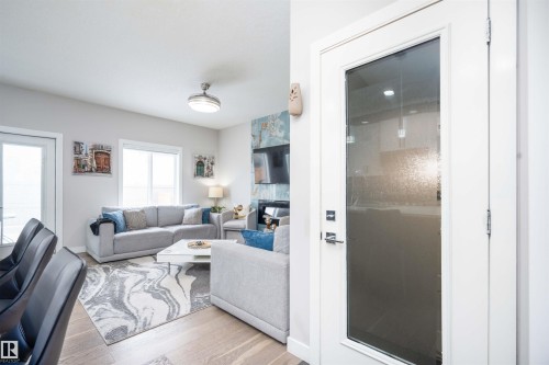 Living room featuring light wood-type flooring and a large fireplace - 43 1703 16 Avenue, Edmonton, AB - Indoor Photo Showing Living Room