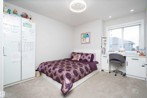 Bedroom with light colored carpet, a textured ceiling, built in desk, and recessed lighting - 43 1703 16 Avenue, Edmonton, AB - Indoor Photo Showing Bedroom