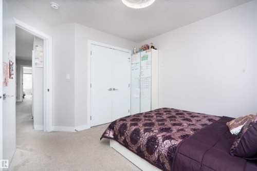 Bedroom with light colored carpet, a closet, and a textured ceiling - 43 1703 16 Avenue, Edmonton, AB - Indoor Photo Showing Bedroom