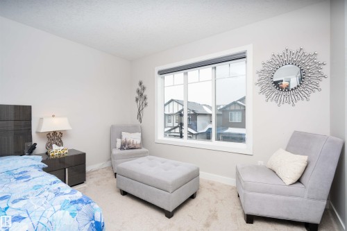 Carpeted bedroom featuring baseboards and a textured ceiling - 43 1703 16 Avenue, Edmonton, AB - Indoor Photo Showing Bedroom