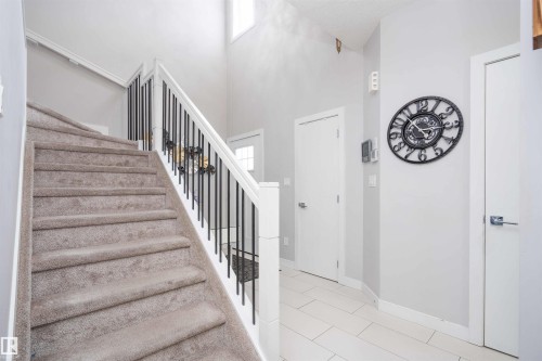 Stairs featuring plenty of natural light, a high ceiling, and tile patterned flooring - 43 1703 16 Avenue, Edmonton, AB - Indoor Photo Showing Other Room