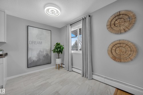 Interior space with a baseboard radiator and a textured ceiling - 201 237 Woodvale Road W, Edmonton, AB - Indoor Photo Showing Other Room