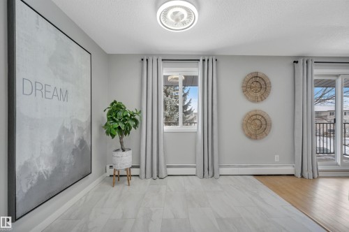 Entrance foyer with a textured ceiling and a baseboard radiator - 201 237 Woodvale Road W, Edmonton, AB - Indoor Photo Showing Other Room