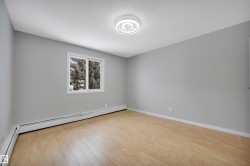 Unfurnished room with a baseboard radiator, light wood finished floors, and a textured ceiling - 