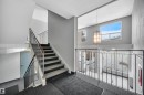 Staircase with a textured wall, carpet floors, a textured ceiling, and hanging lights - 201 237 Woodvale Road W, Edmonton, AB  - Indoor Photo Showing Other Room 